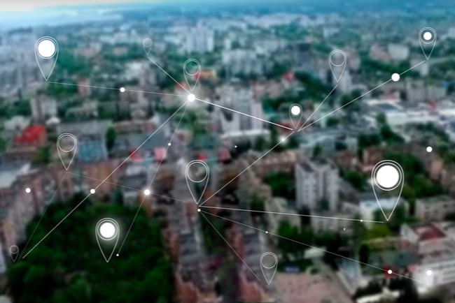 Ett flygfoto över en stad med symboler som visar platsposition som ett nät över staden.